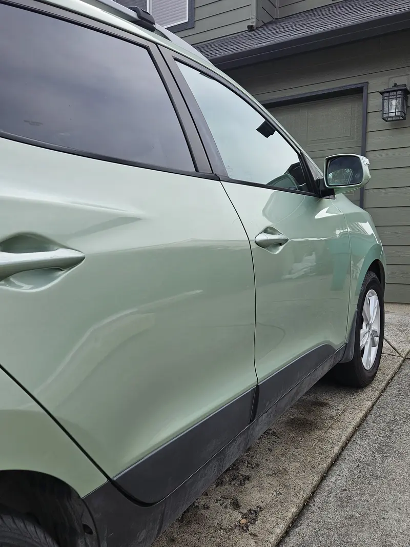 Side of a green Hyundai Tucson after an exterior hand wash