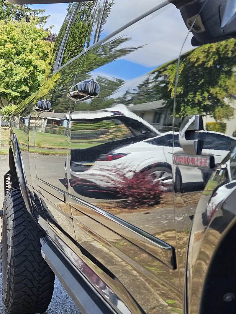 Side panel of a RAM 1500 4x4 reflecting the street after a hand wash in Vancouver WA